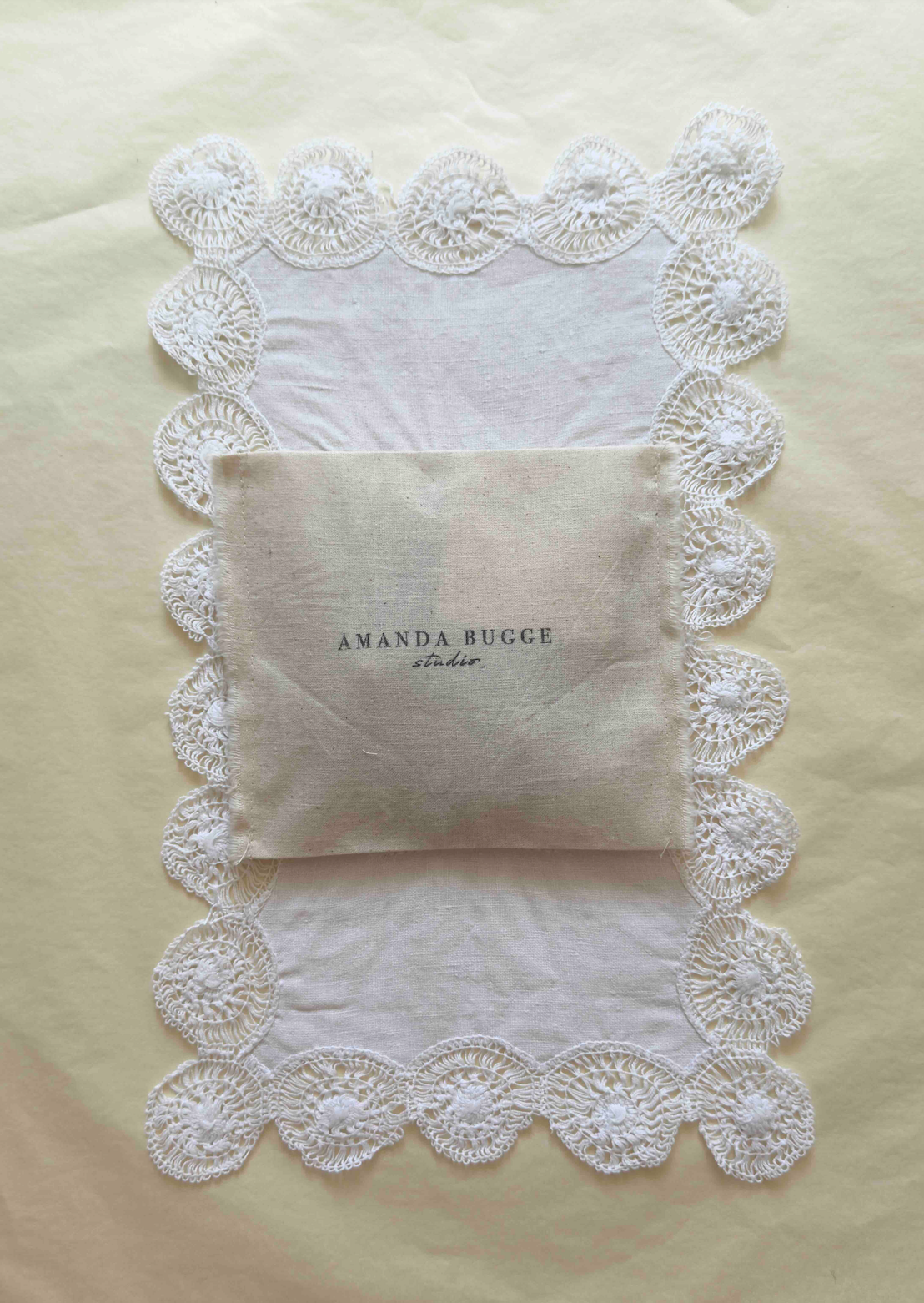 AMANDA BUGGE studio cotton jewelry pouch on lace background