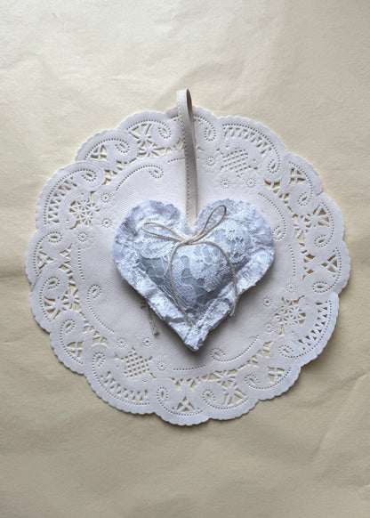White lace Christmas heart in textile by AMANDA BUGGE studio with a ivory bow on 
