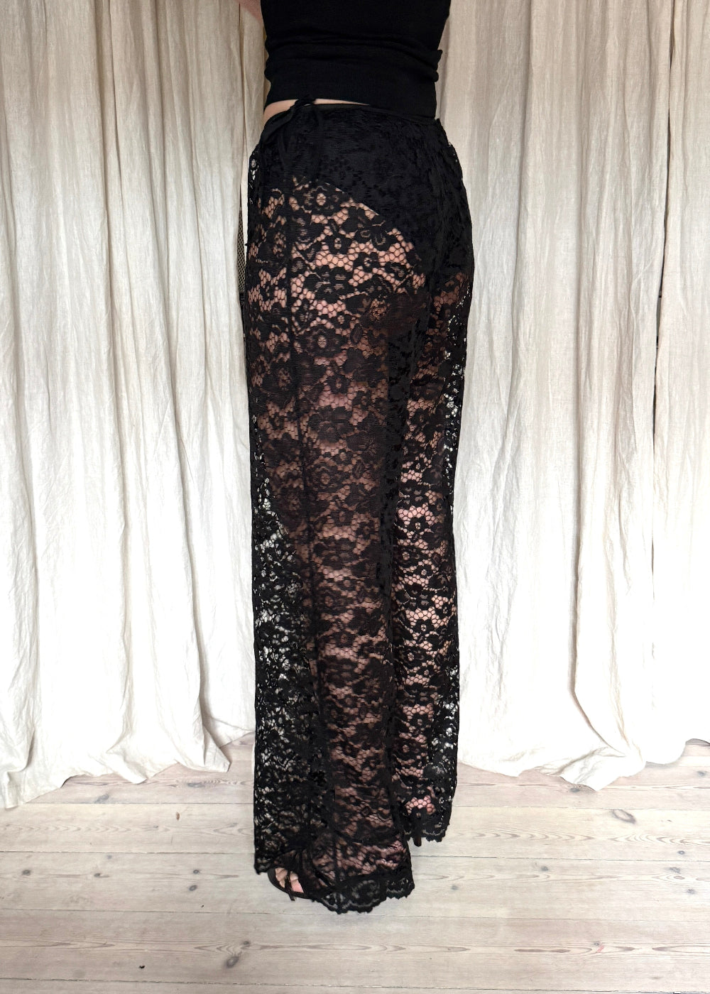 Model wearing black Nora Lace Pants in sheer lace with a relaxed fit and drawstring waist