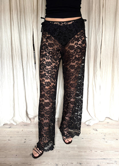 Model wearing black Nora Lace Pants in sheer lace with a relaxed fit and drawstring waist